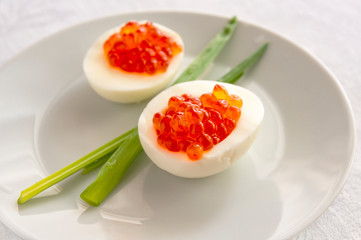 egg halves with red caviar served with green onion