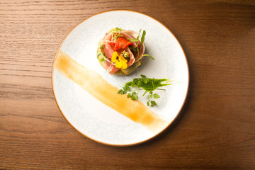 
Unusual beautiful serving plate on a wooden background. Plate, diet, delicious food, healthy food, lunch in a restaurant, greens