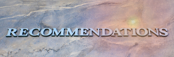 recommendations , writen wooden letters on stone background