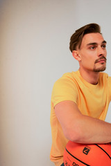 Hombre con balon de baloncesto mirando al horizonte