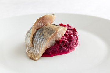 mayonnaise based beetroot garlic salad accompanied with freshly salted herring