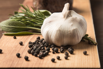 Head of garlic with sprinkled black pepper peas and greens. Vegetables, seasoning, taste, spicy, aroma