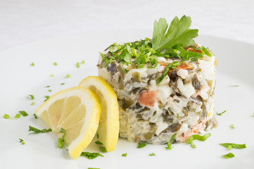 tower salad with seaweed and chum salmon dressed with mayo seved with lemon slices and decorated with parsley