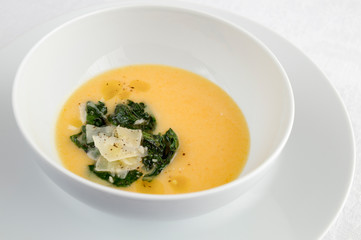 pumpkin cream soup decorated with spinach and cheese