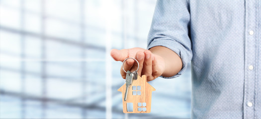 Real estate agent handing over house keys in  hand