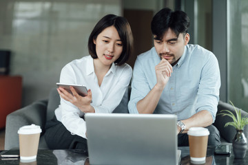 Obraz premium Two young Asian business men and women are working