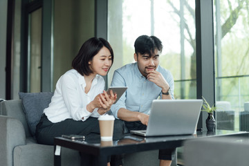 Two young Asian business men and women are working