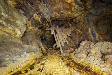 Abandoned copper ore mine underground tunnel with collapsed wooden timbering