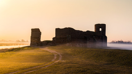 Ruiny zamku w Kole z drona o wschodzie słońca nad Wartą we mgle - obrazy, fototapety, plakaty