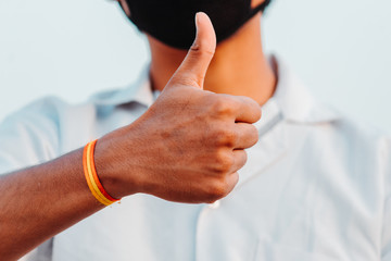 Closeup of hand of an Indian doctor showing thumbs up during the corona virus pandemic