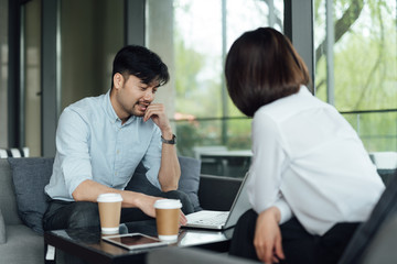 Two young Asian business men and women are working
