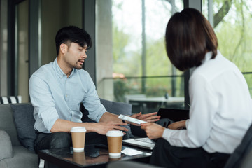 Two young Asian business men and women are working