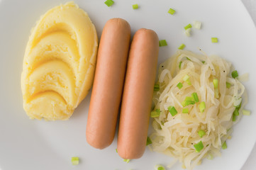 sausages, stewed cabbage, and mashed potatoes sprinkled with green onion