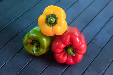 Assorted peppers. Vegetarian still life. Peppers of different colors. Red, yellow, and green, like a traffic light. Vegetables on a wooden table