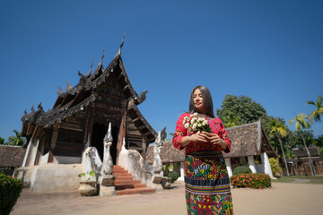 Asian beautiful woman wearing Thai north traditional clothing and walking in old temple in Chiang-mai, Thailand.