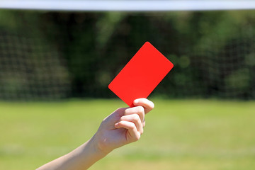 hand holding a soccer red card in a football game. © dean