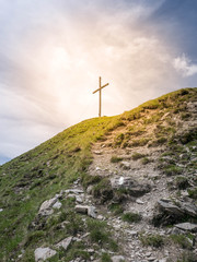 Orange light around a cross on top of a mountain - a sign of God.