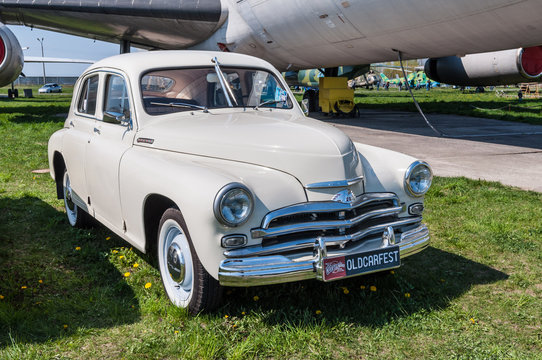 Kyiv, Ukraine - April 26, 2015: The festival "Old Car Fest 2015", showed an old soviet 1955 Pobeda M-20 vintage model at April 26, 2015 in Kiev, Ukraine. Passenger aircraft IL-86 in the background.