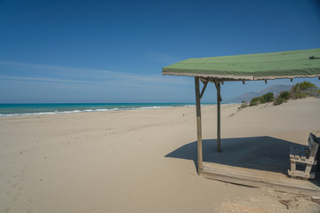 Canopy over a bench on a deserted beach