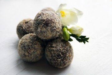 Healthy homemade chocolate rum truffles with white flower on a white background. Tasty sweeties.