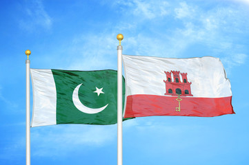 Pakistan and Gibraltar two flags on flagpoles and blue cloudy sky