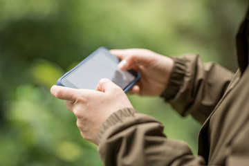 Hiker hands using mobile phone in spring nature