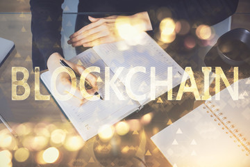 Cryptocurrency hologram over woman's hands writing background. Concept of blockchain. Multi exposure