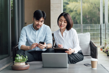 Two young Asian business men and women are working