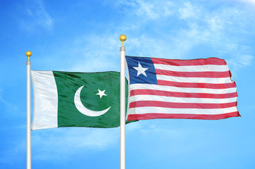 Pakistan and Liberia two flags on flagpoles and blue cloudy sky