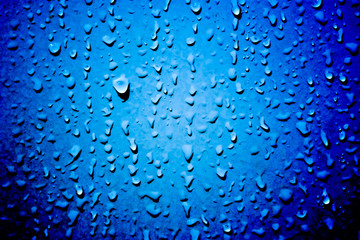 Water droplets background on the dark blue wall with heavy noise effects for water conservation concepts