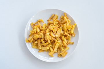 French fries on a plate, isolated on white background