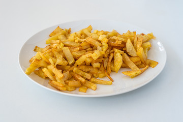 French fries on a plate, isolated on white background