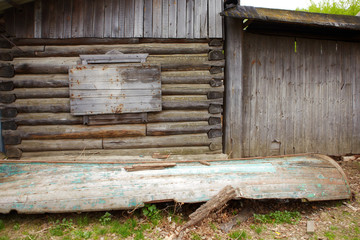 An old wooden hut and a rotten wooden boat.