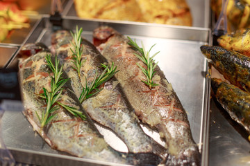 baked fish with cilantro on the counter in the store