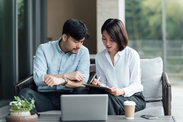 Two young Asian business men and women are working