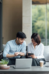 Two young Asian business men and women are working