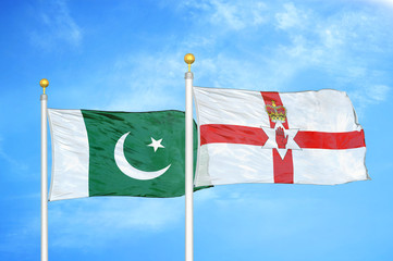 Pakistan and Northern Ireland two flags on flagpoles and blue cloudy sky