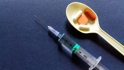 Capsules and syringe on dark background. medical capsules with syringe isolated. selective focus. Copy space.