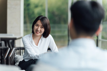 Two young Asian business men and women are working