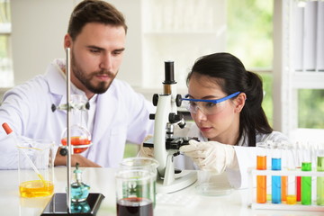 Scientists are working in science labs.Close-up of a scientistYoung female scientist looking through a microscope in a laboratory doing research, microbiological analysis, medicine for kovid 19.