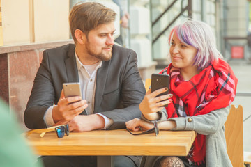 Handsome man looks tenderly into the eyes of a young beautiful woman and takes at the same time selfie. Tenderness, love, lifestyle concept.