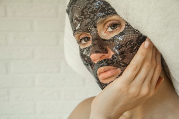 woman in spa wearing black lace hydrogel mask