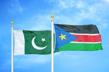 Pakistan and South Sudan two flags on flagpoles and blue cloudy sky