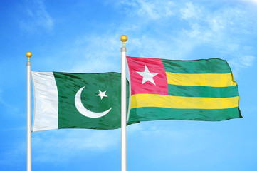 Pakistan and Togo two flags on flagpoles and blue cloudy sky