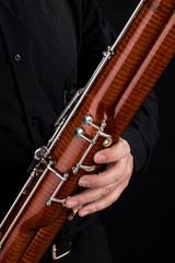 Wooden bassoon isolated on a black background. Musical instruments. Musician playing the instrument.