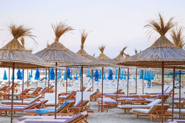 Beach thatched umbrellas on the beach promenade.