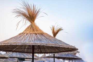 Beach thatched umbrellas on the beach promenade.