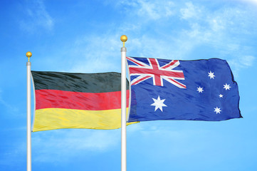 Germany and Australia two flags on flagpoles and blue cloudy sky