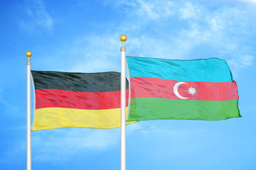 Germany and Azerbaijan two flags on flagpoles and blue cloudy sky