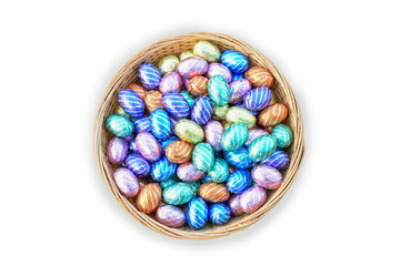 Colorful chocolate Easter eggs in basket isolated on white background.